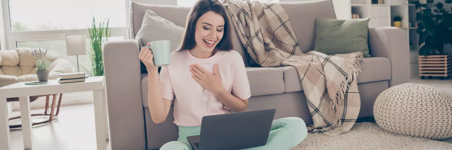 mujer_sentada_con_una_laptop_sujetando_una_taza